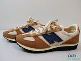 the new balance 995 sneakers are tan and blue with a blue stripe on the side