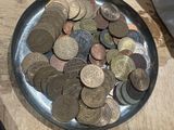 a bowl of coins sitting on a table next to a computer mouse