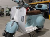 un cyclomoteur bleu et blanc garé dans un garage