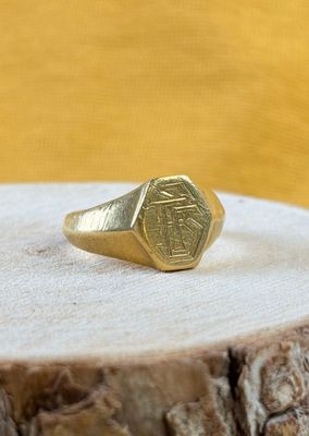 an image of a gold signet ring on a piece of wood
