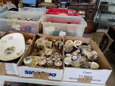 Plusieurs cartons contenant des objets divers sont posés sur une table dans une pièce