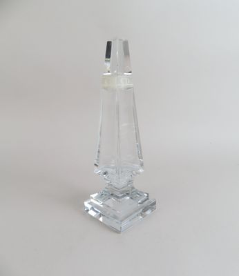 un bougeoir en verre transparent posé sur une surface blanche