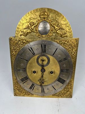 une horloge dorée et argentée posée sur une surface blanche