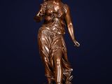 a bronze statue of a woman holding a flower