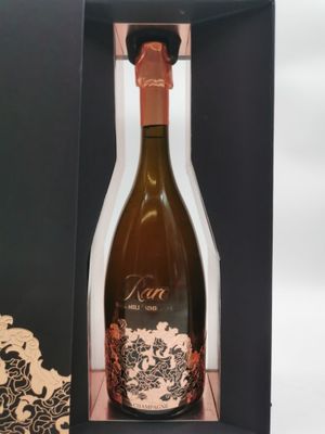 une bouteille de vin dans un coffret noir orné d'un motif en dentelle
