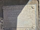 une plaque apposée sur le mur d'un immeuble, près d'une borne d'incendie