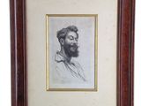 une vieille photo d'un homme barbu dans un cadre en bois