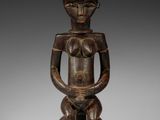 une figurine en bois représentant un homme tenant un bébé dans ses bras
