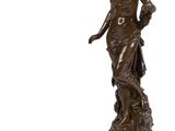 une statue de bronze représentant une femme debout sur un piédestal
