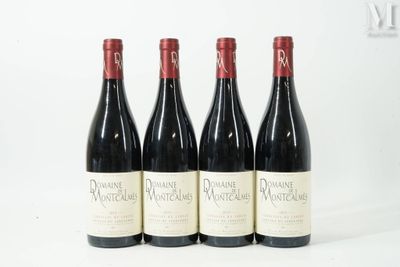 quatre bouteilles de vin sont alignées sur une surface blanche