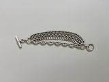 a close up of a silver chain bracelet on a white surface
