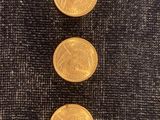 trois pièces d'or empilées les unes sur les autres sur un tissu noir