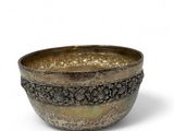 a close up of a metal bowl on a white surface