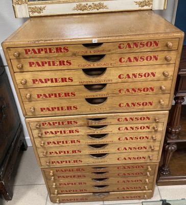 une commode en bois à cinq tiroirs, surmontée d'un tableau
