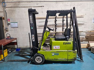 a forklift in a warehouse with pallets in the background