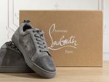 grey sued sneaker in front of a box on a wooden floor