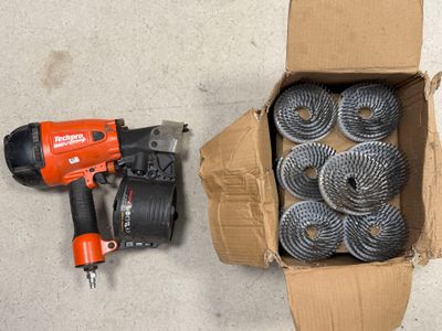 une boîte de bobines et une perceuse sans fil posées par terre