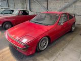 two red cars parked next to each other in a garage