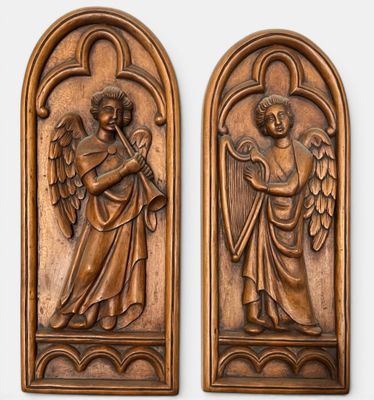 a pair of carved wooden plaques depicting angels