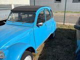a small blue car that is parked in the grass