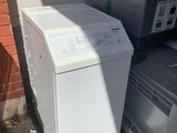a white washing machine sitting next to a stack of other appliances