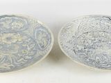 une paire de bols bleus et blancs ornés de motifs sur fond blanc