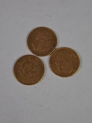 three british coins sitting on top of each other on a white surface