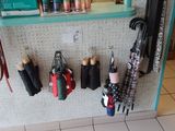 de nombreux parapluies accrochés à un panneau perforé dans une pièce