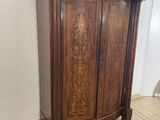 a wooden armoire in the middle of a tiled floor