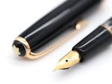 two pens sitting next to each other on a white surface