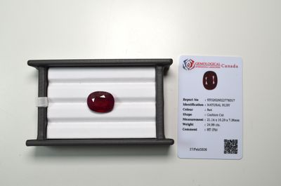a close up of a red ruby stone in a white box