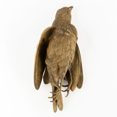 une image représentant une statue d'oiseau accrochée à un mur