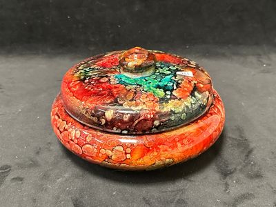 une boîte rouge et verte posée sur une surface noire