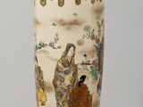 a vase with a painting on it sitting on a table