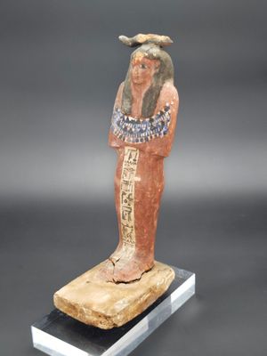 une statue égyptienne représentant un homme coiffé d'un chapeau