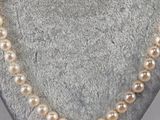 a close up of a pearl necklace on a mannequin display