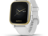 the garmin watch is white and gold with a black face