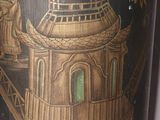a black and gold vase with a picture of a pagoda on it