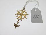 a close up of a gold cross on a string with a price tag