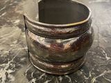 bracelet manchette plaqué argent posé sur un comptoir en marbre