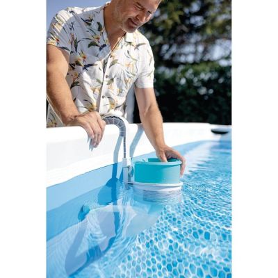Cet homme nettoie sa piscine avec un seau bleu.