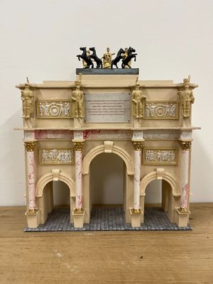 a small model of a building on a wooden table