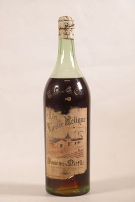 une vieille bouteille de vin posée sur une table blanche