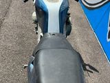 une moto bleue garée sur le bord de la route