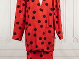 a red and black polka dot dress and jacket on a mannequin