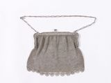 an old silver purse with chain hanging from it ' s side