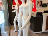 trois mannequins qui se tiennent devant la vitrine d'un magasin