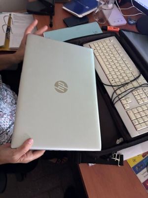 une femme assise à un bureau, devant un ordinateur portable et un clavier