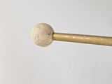 a close up of a person holding a wooden mallet with a ball on it