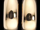 une paire de bougies blanches et dorées ornées de pierres noires